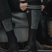 a man putting on Banked Ski Socks with 3/4 length base layer bottoms