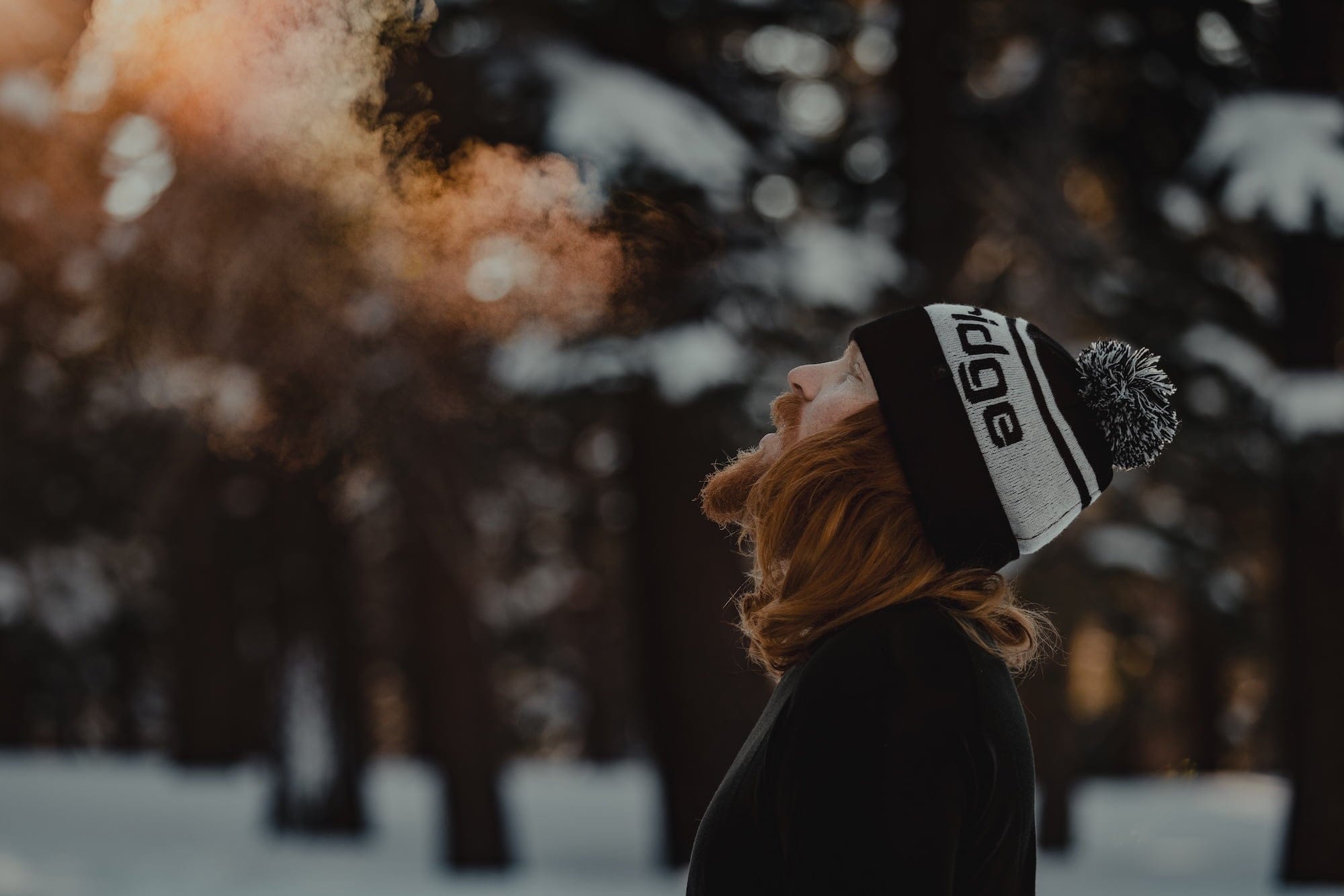 a man breathes in cold air wearing a Ridge team beanie