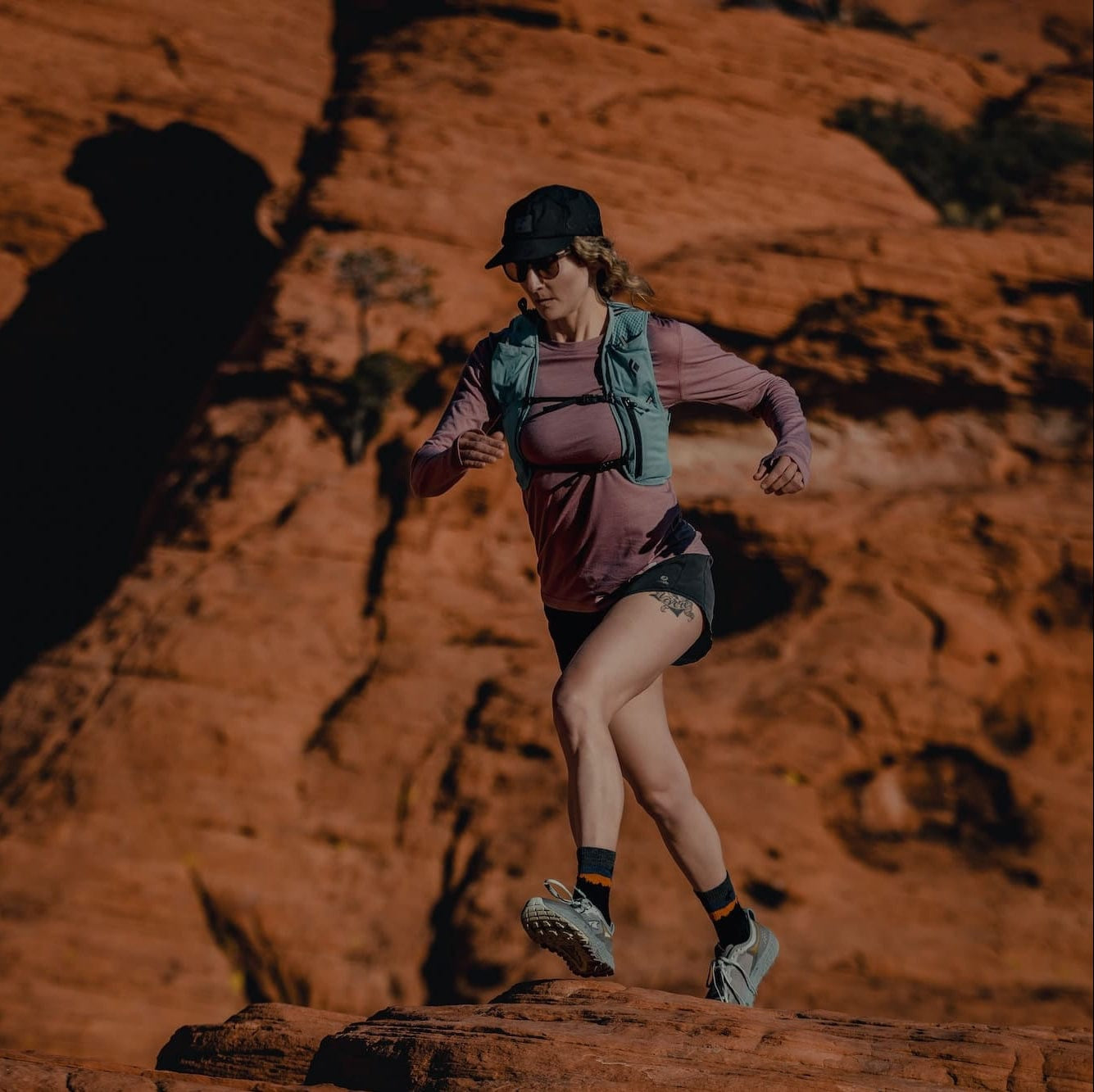 a woman running in a Ridge Pursuit Ultralight Long Sleeve Shirt and Minaret Running Socks