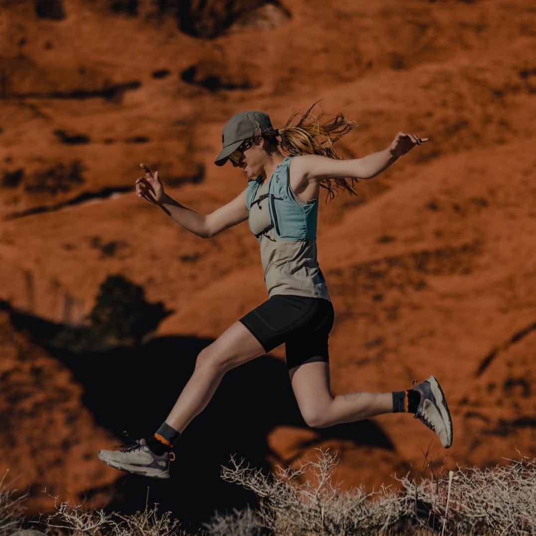 a woman jumping in a Wander Tank, Hilltop Shorts and Minaret Socks