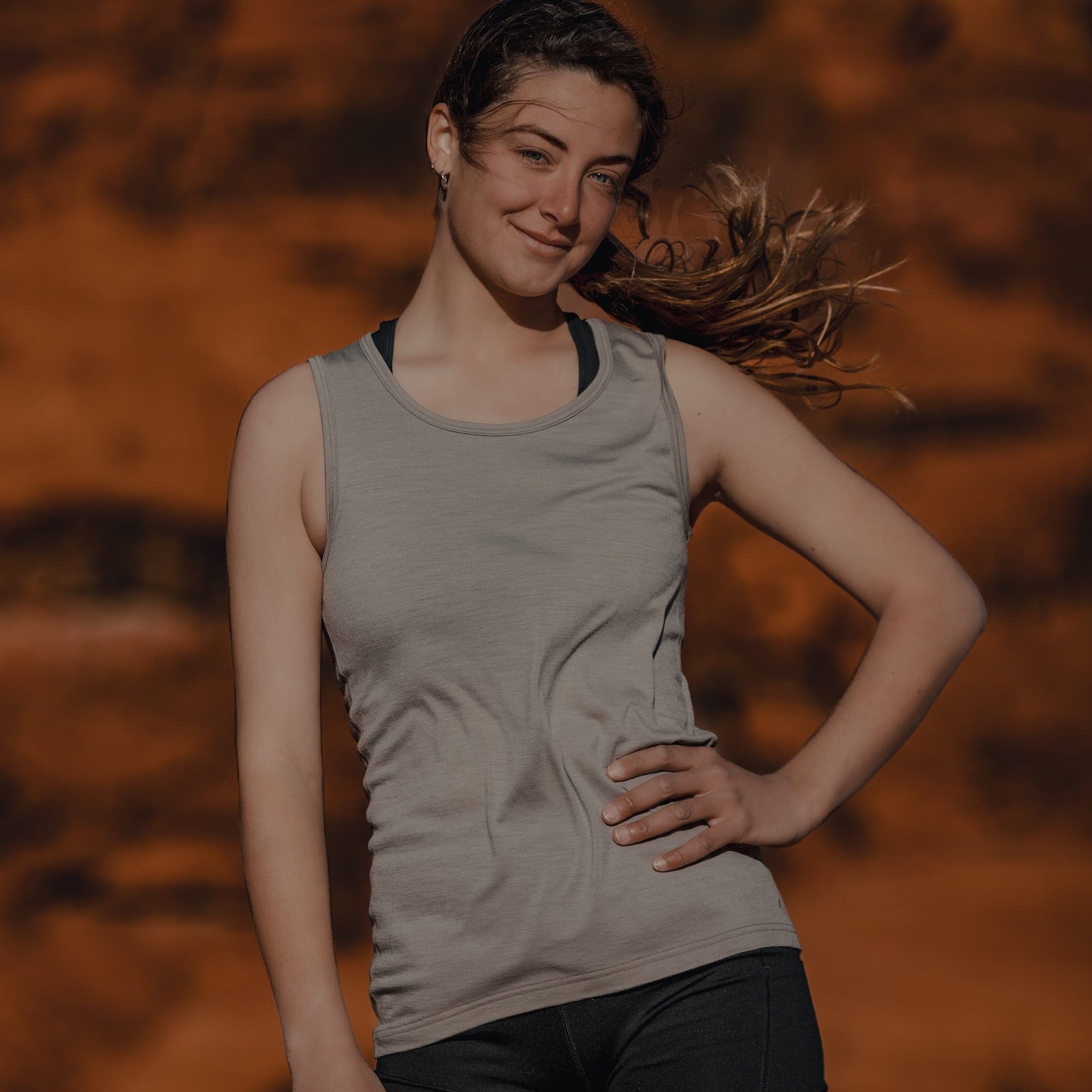 a woman smiling wearing a Wander Merino Tank Top