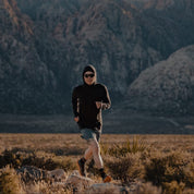 a man running in a black Pursuit Air Hoodie