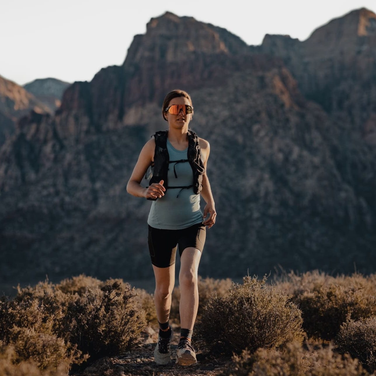 a woman running in a Ridge Racerback Merino Tank