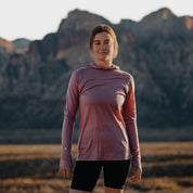 a woman wearing a Pursuit Ultralight Merino Hoodie