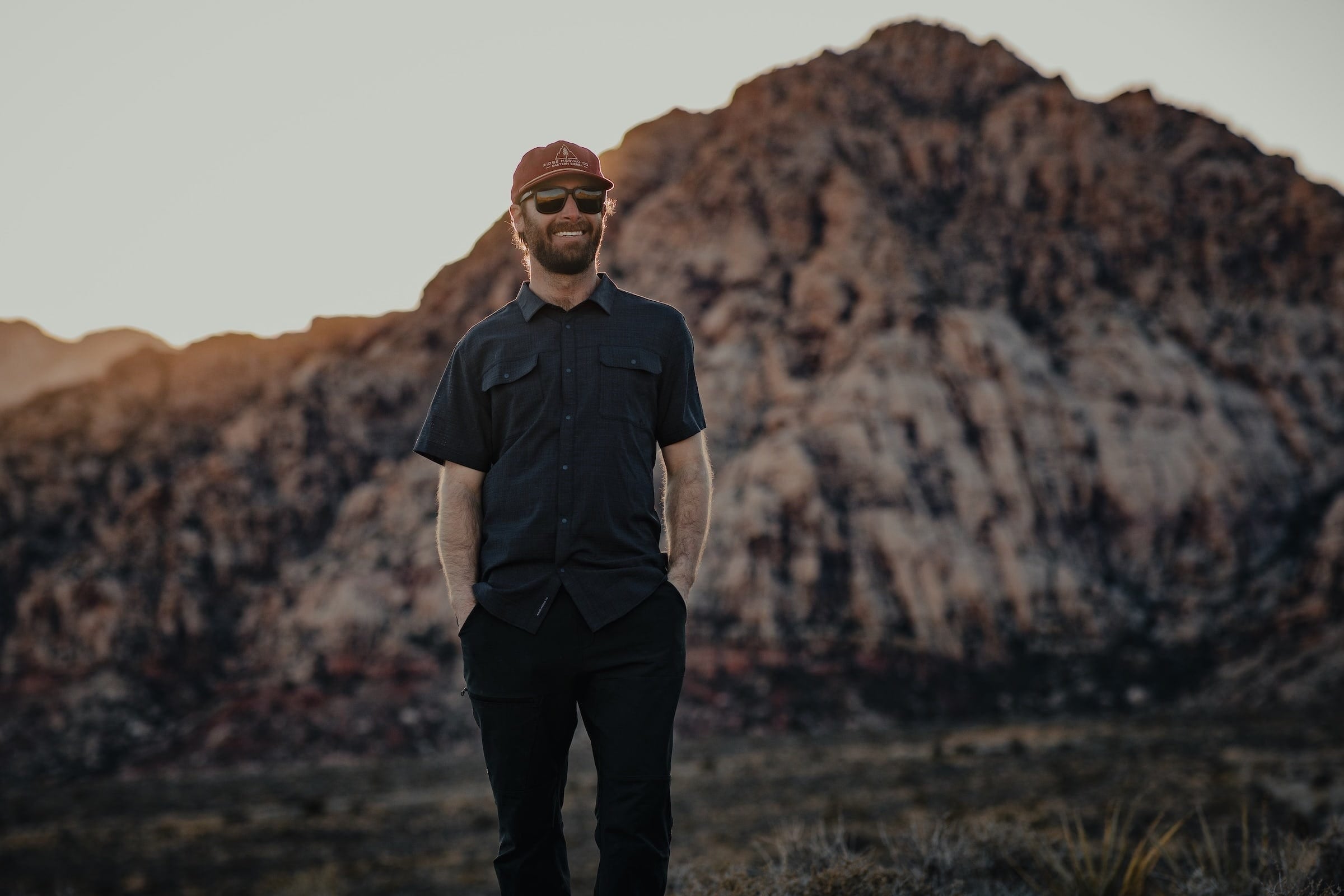 a man wearing a High Country Button Down Short Sleeve Shirt and a Ridge hat