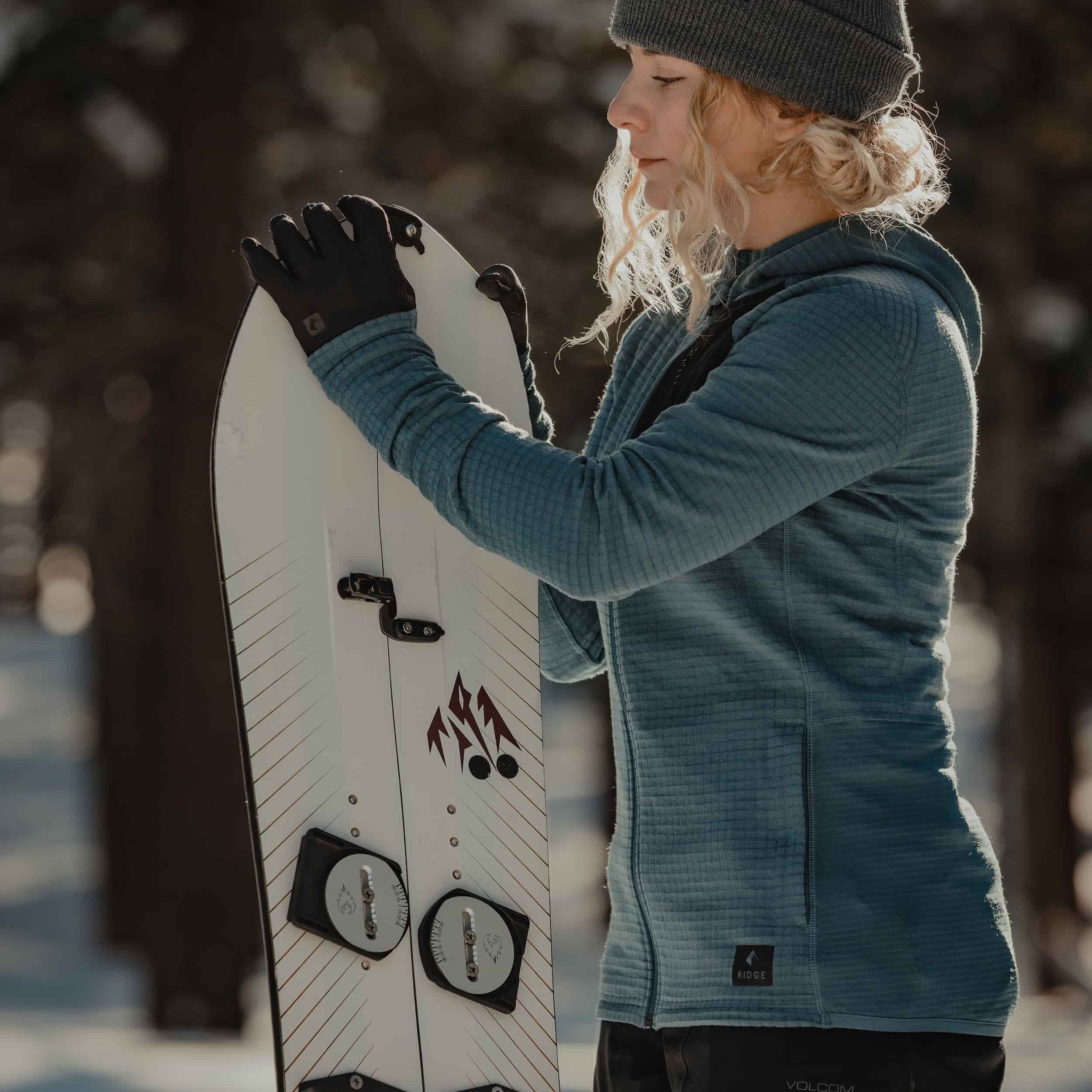 a woman preparing her splitboard wearing a Cloudripper Grid Fleece Jacket