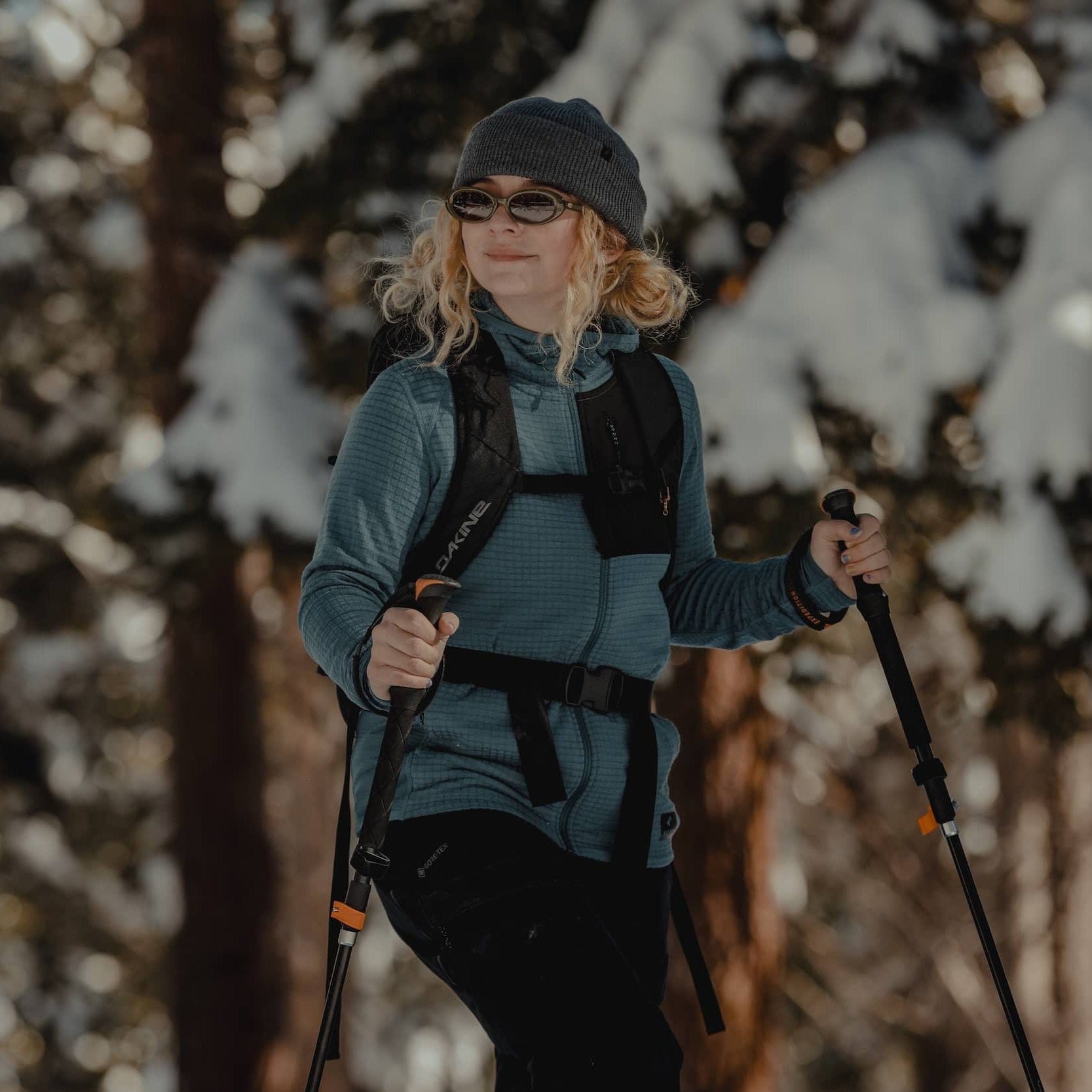 a woman backcountry skiing wearing a blue Cloudripper Full Zip Hoodie