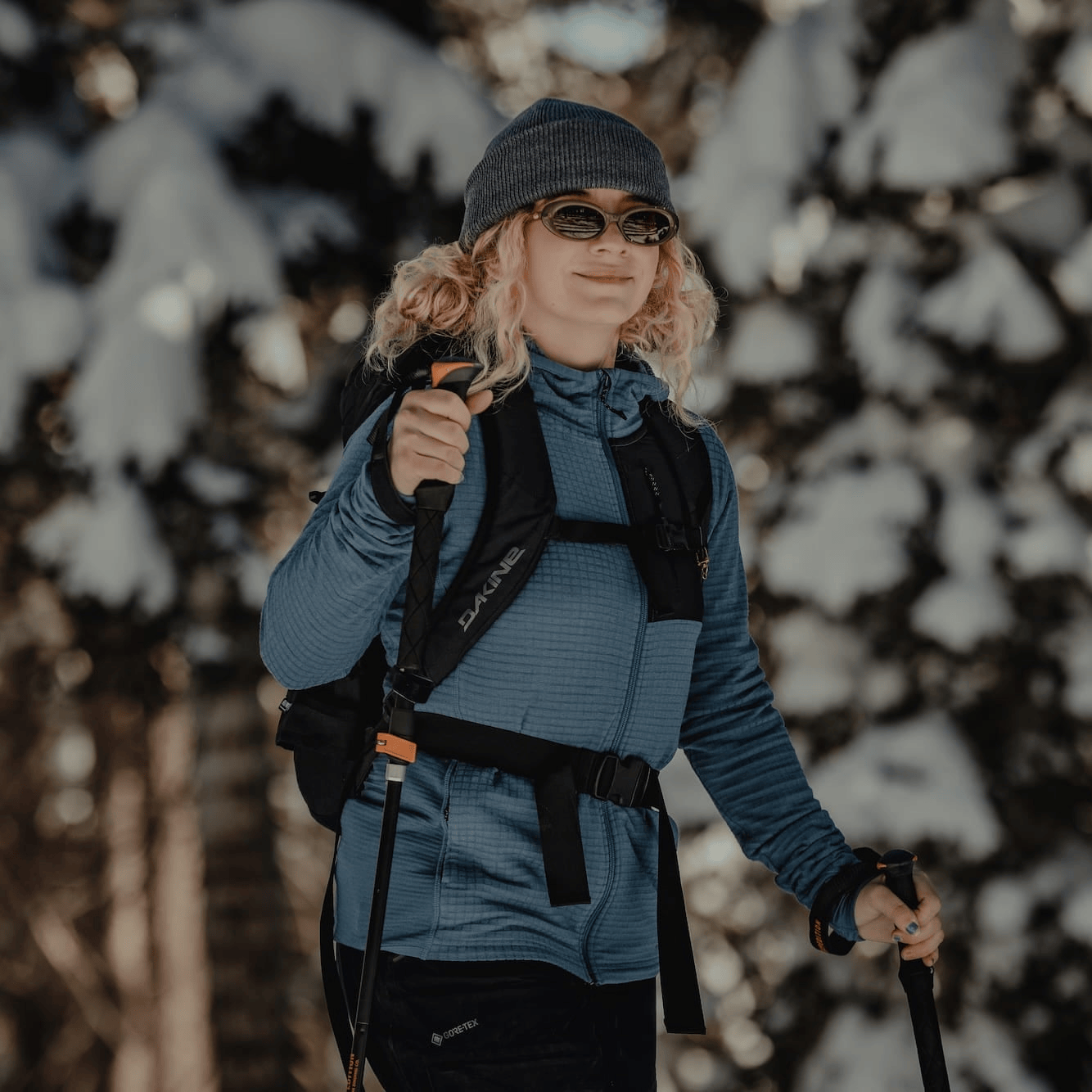 a woman wearing a Cloudripper Full Zip Hoodie on a ski tour in the snowy forest