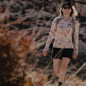 a woman hiking in a tie-dye Solstice Sun Hoodie