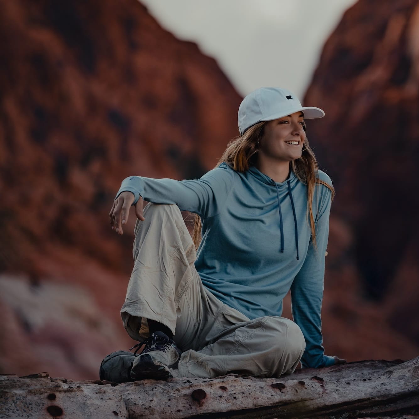 a woman wearing a Solstice Merino Sun Hoodie and hat