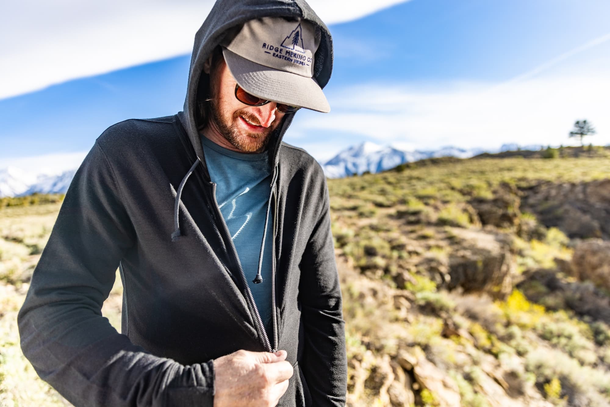 a man zipping up his Traveler Merino Hoodie