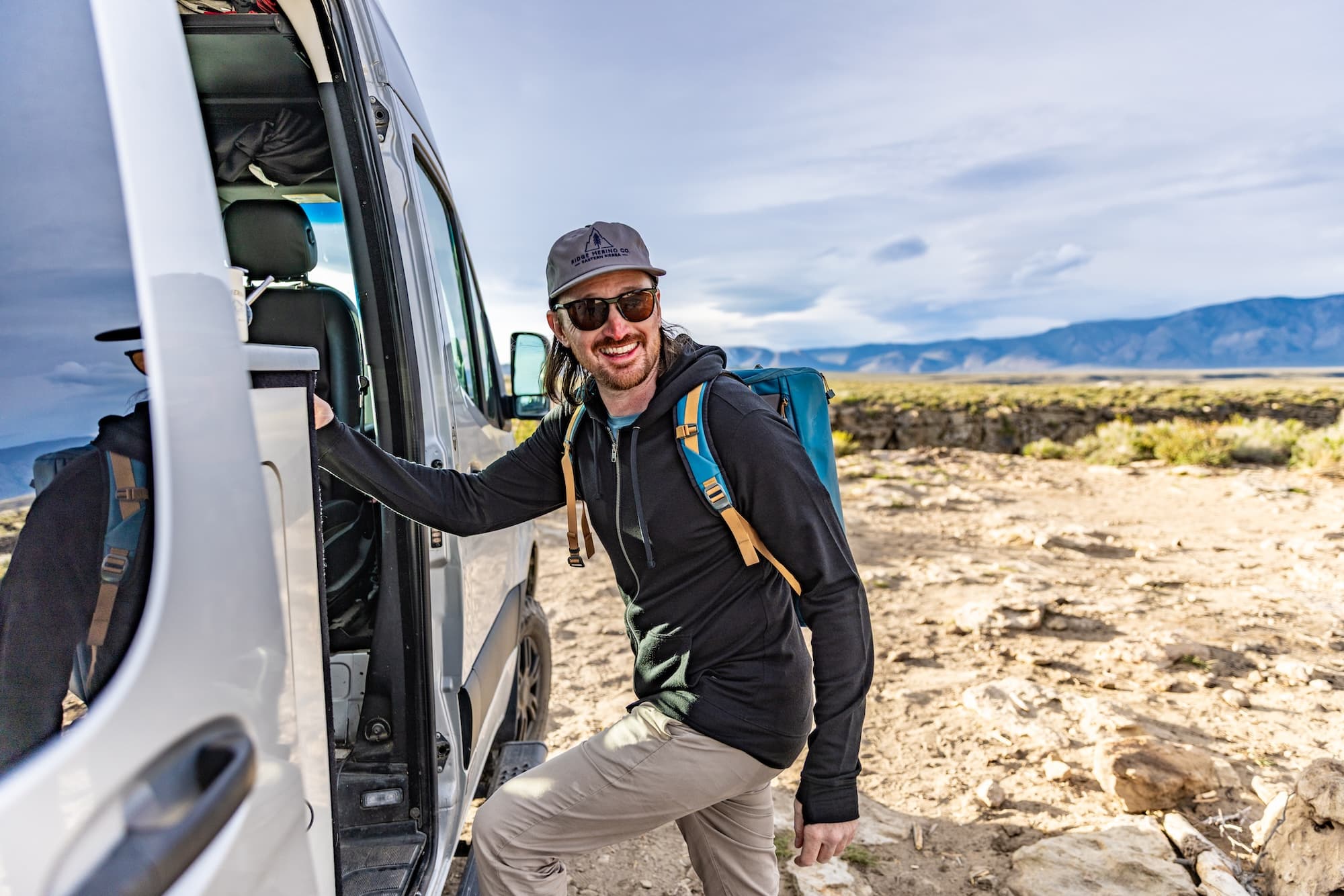 a man getting in a camper van wearing a Traveler Merino Hoodie