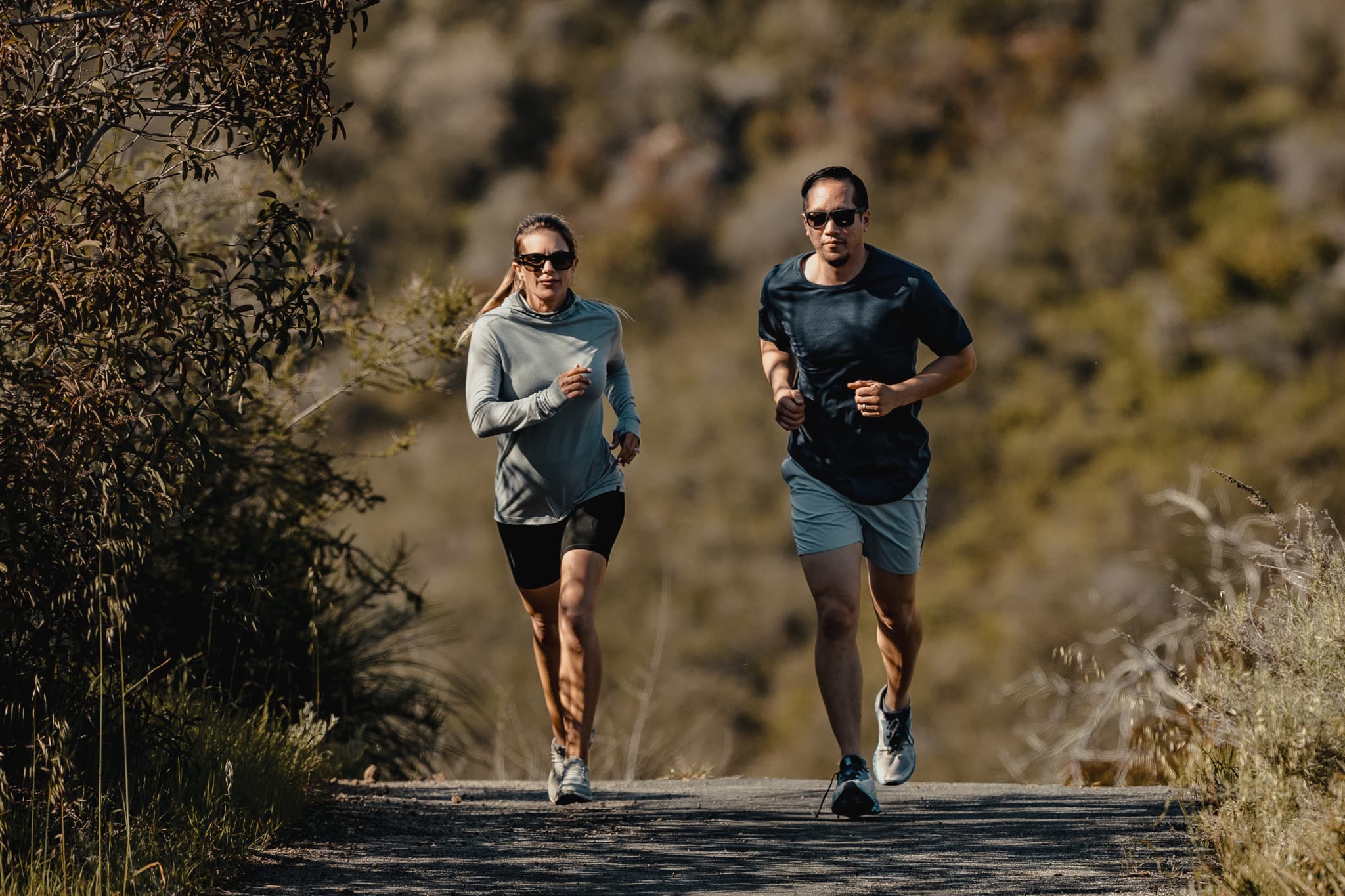 a man and a woman going for a run; the woman is wearing the Pursuit Hoodie and the man is wearing the Pursuit tee