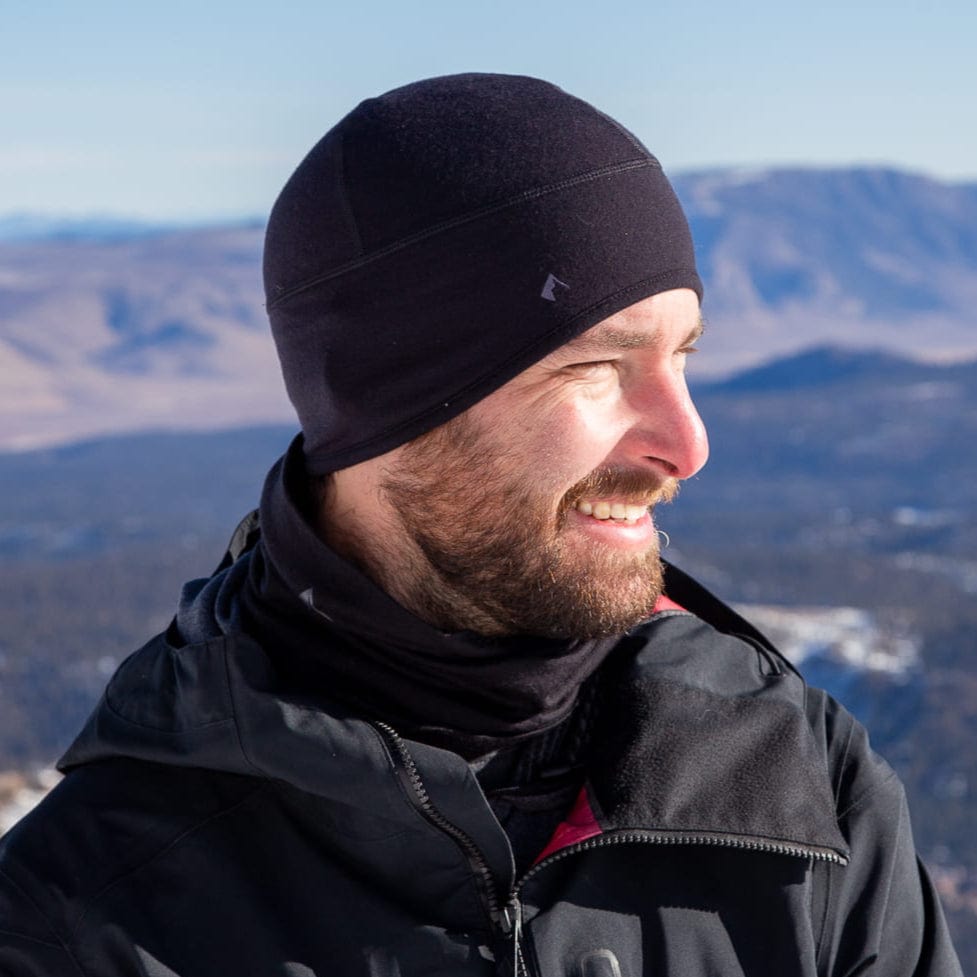 a skier wearing an Aspect Beanie and a Ridge Merino Neck Gaiter bunched down when not in use