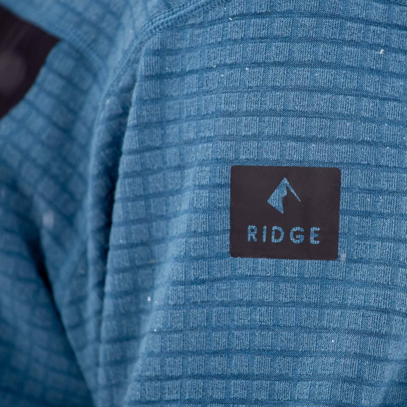 closeup of the Ridge logo on the arm of the Cloudripper Grid Fleece Half Zip Pullover