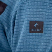 closeup of the Ridge logo on the arm of the Cloudripper Grid Fleece Half Zip Pullover