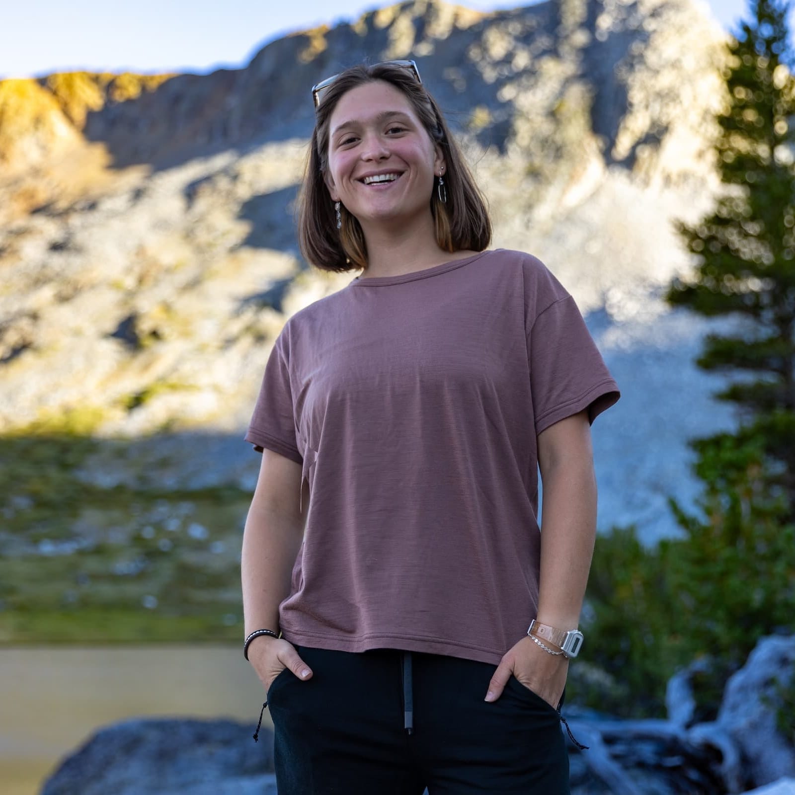 a woman smiling in the mountains wearing a Ridge Merino Wool Oversized T-Shirt