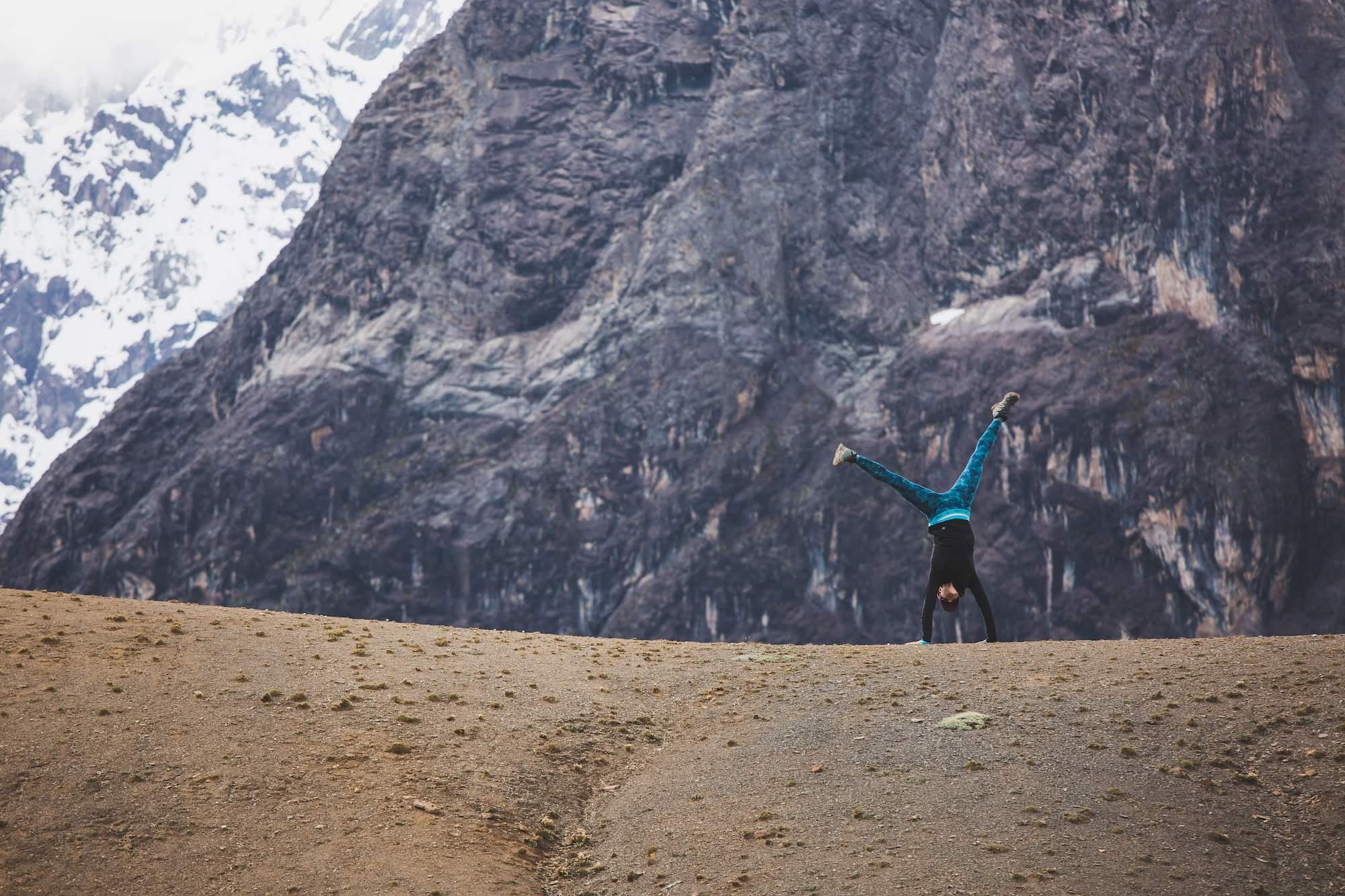 a woman doing a cartwheel while on a mountain vacation in South America