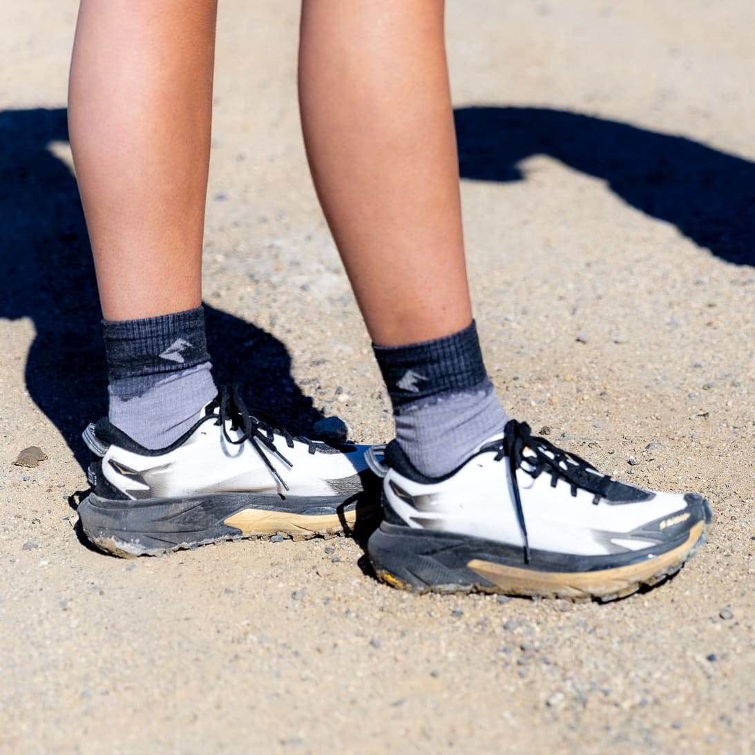 a woman wearing gray Minaret Hiking Socks and running shoes