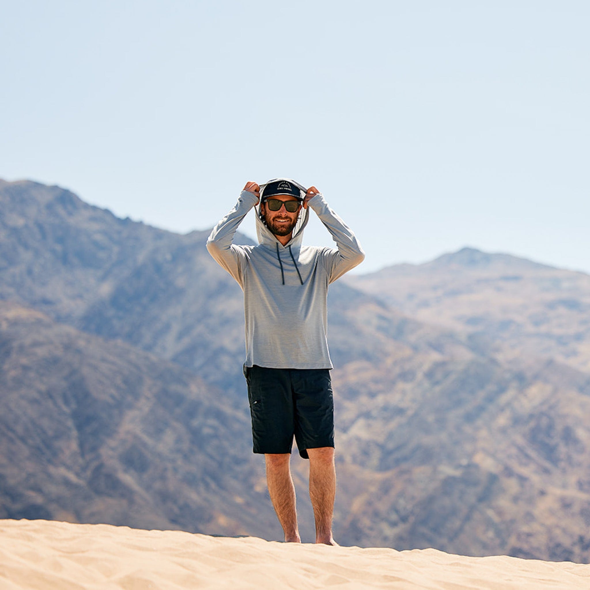 a man walks through the desert wearing the Solstice Sun Hoodie