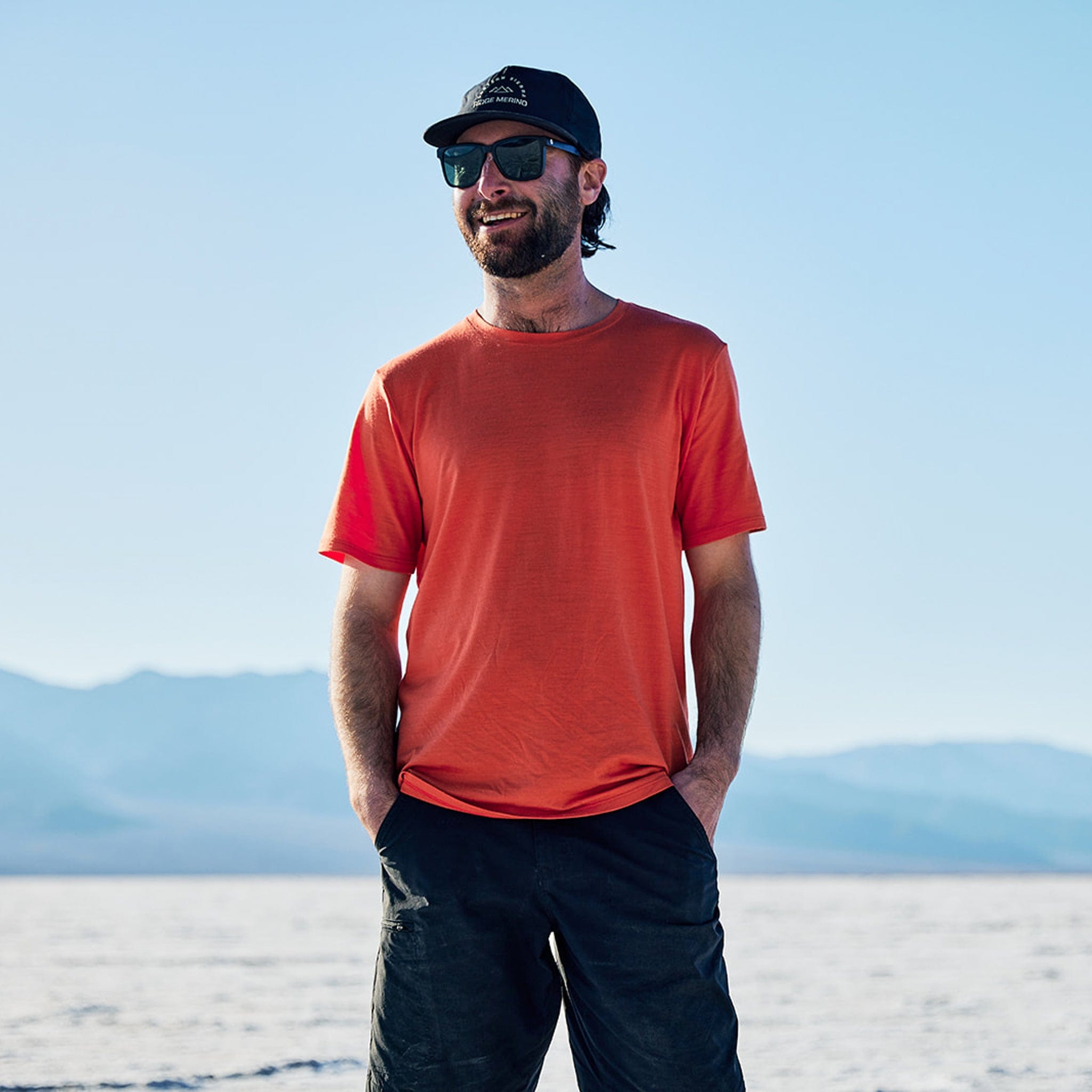 a man smiles in Death Valley wearing a Journey Merino Wool T-Shirt and Ridge Merino hat