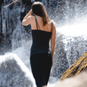 A woman admires a waterfall on a hike wearing the Ridge shelf bra cami