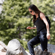 A woman hikes wearing sunglasses and the Ridge Merino wool shelf bra camisole